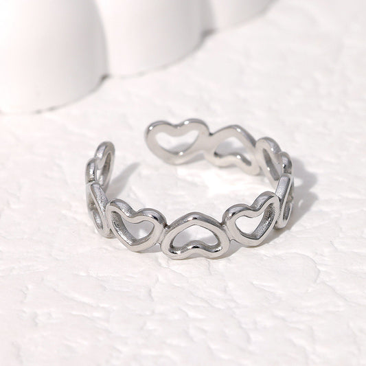 silver heart-shaped ring on white background