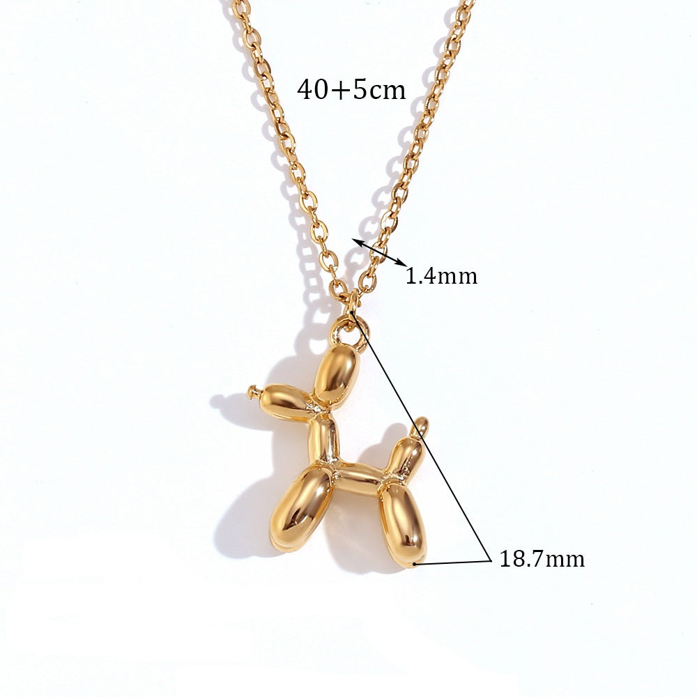 Gold balloon dog pendant necklace with measurements on a white background