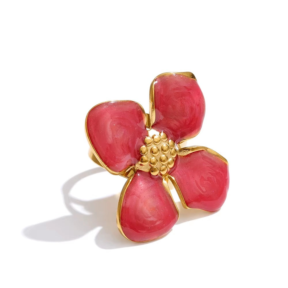 Red flower-shaped ring with gold accents on a white background
