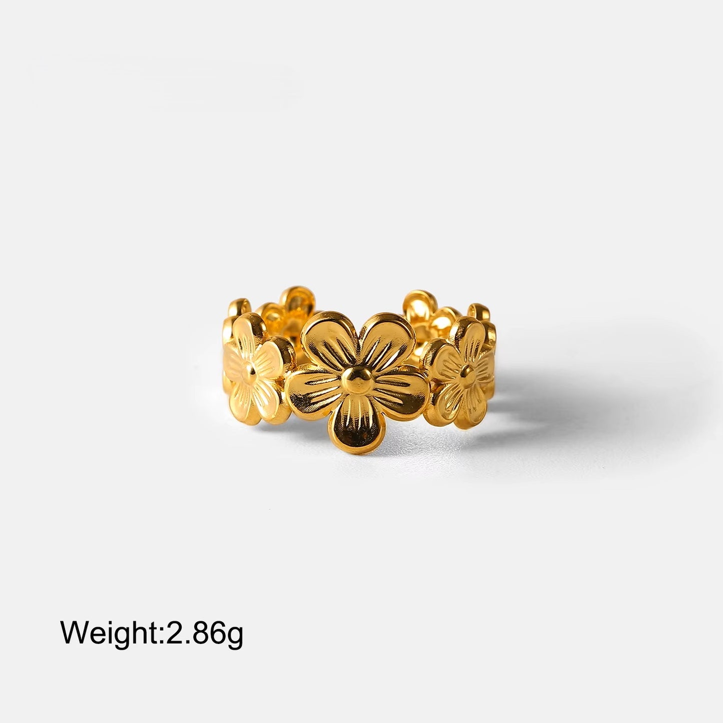 Gold floral ring on a white background with weight displayed