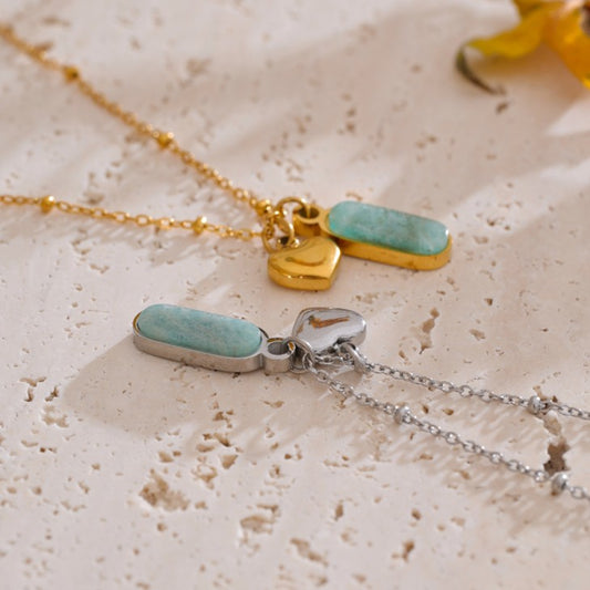 Two necklaces with turquoise pendants on a textured beige surface