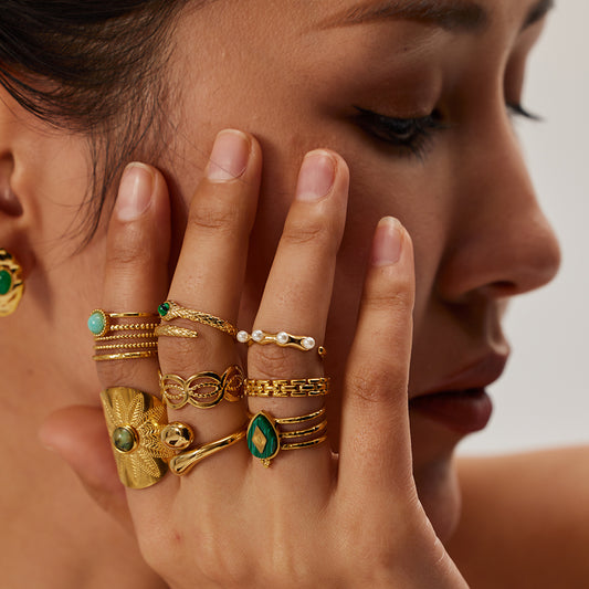 Close-up of a woman's hand wearing multiple gold rings with gemstones.