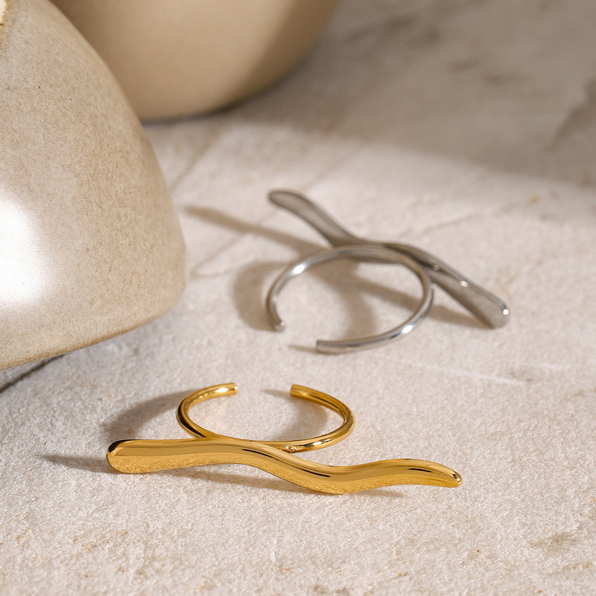 Gold and silver rings on a textured beige surface