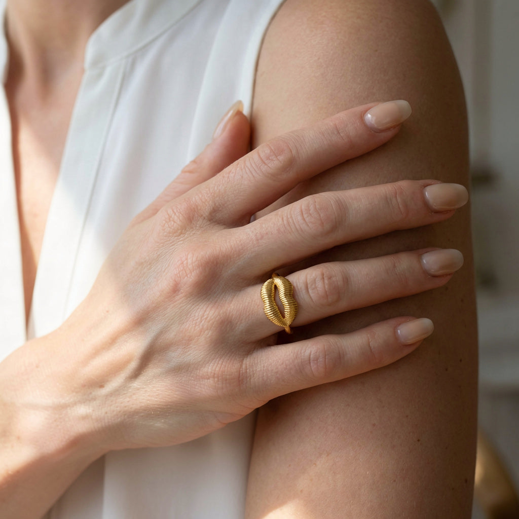 Hand wearing a gold ring on a blurred background