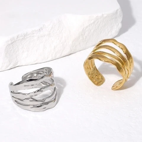 Gold and silver open rings on a textured white surface