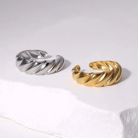 Silver and gold twisted ring pairs on a white background