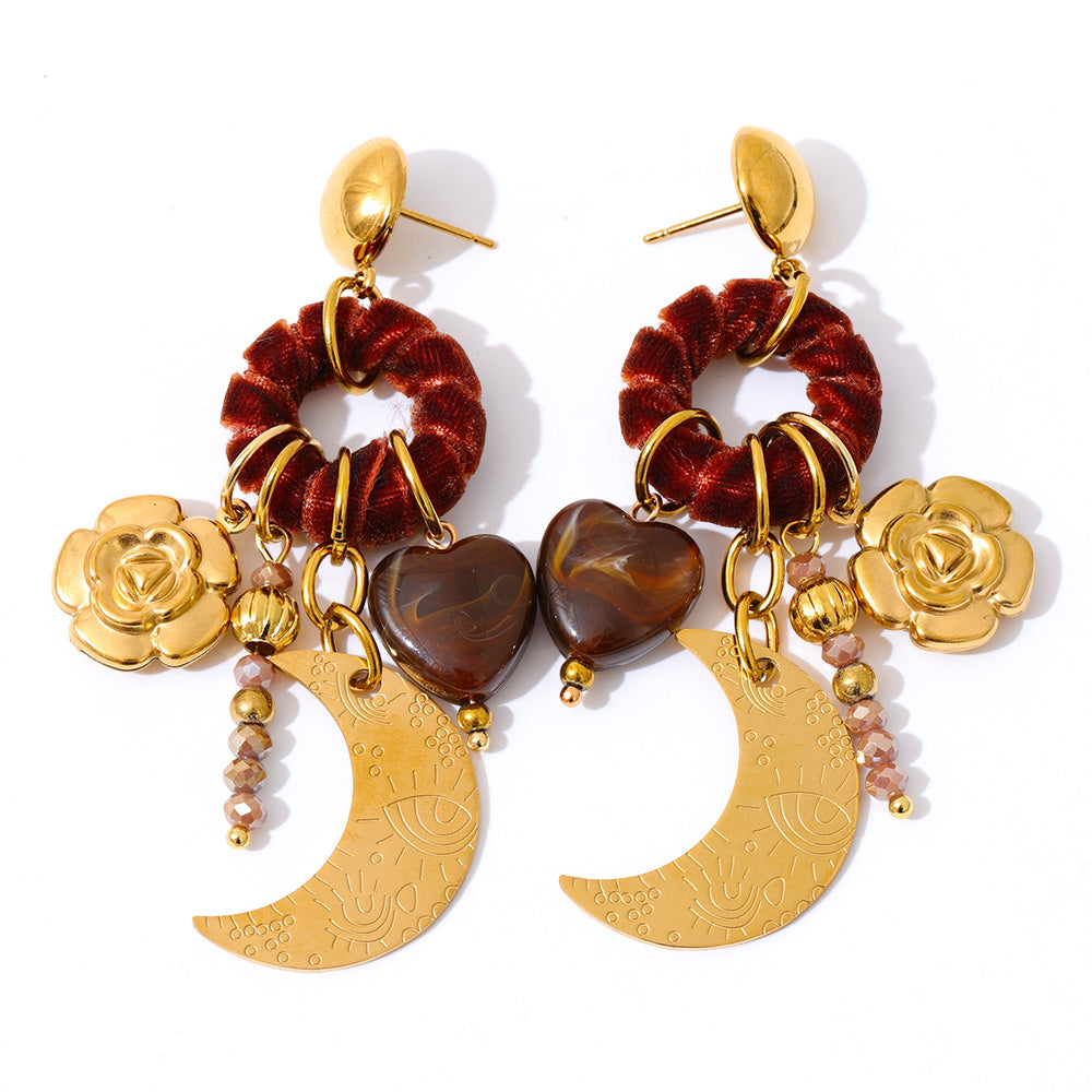 Pair of earrings with gold and red elements on a white background