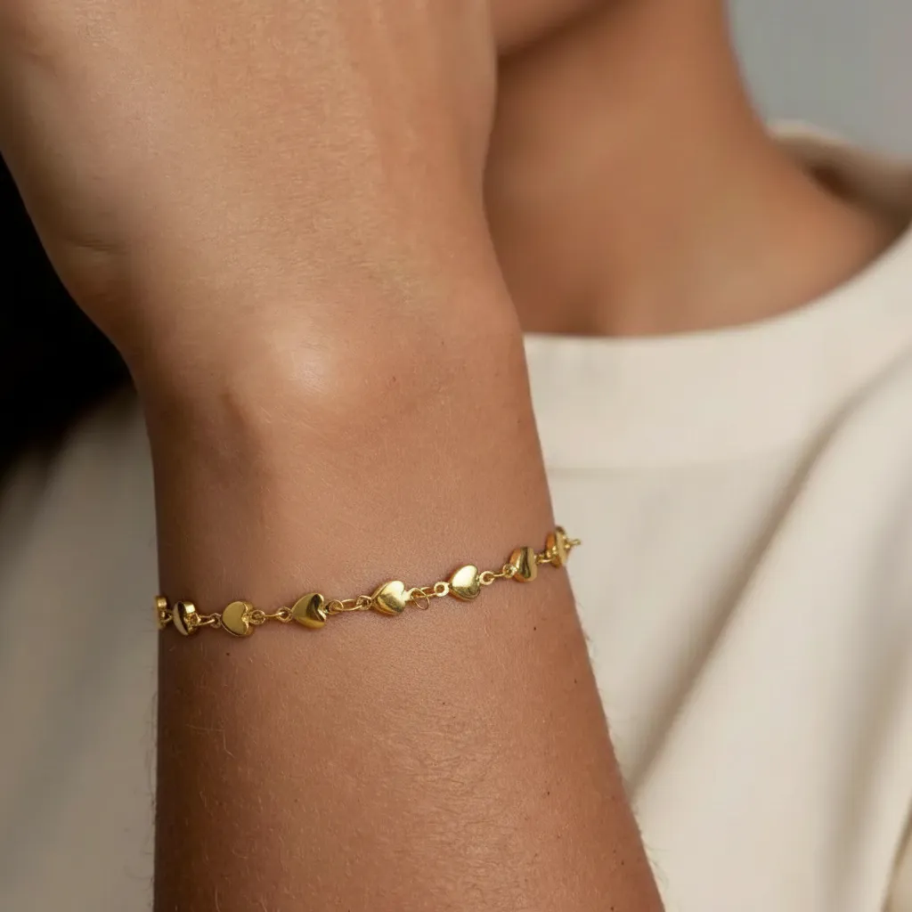 Gold stainless steel bracelet on a wrist with a neutral background