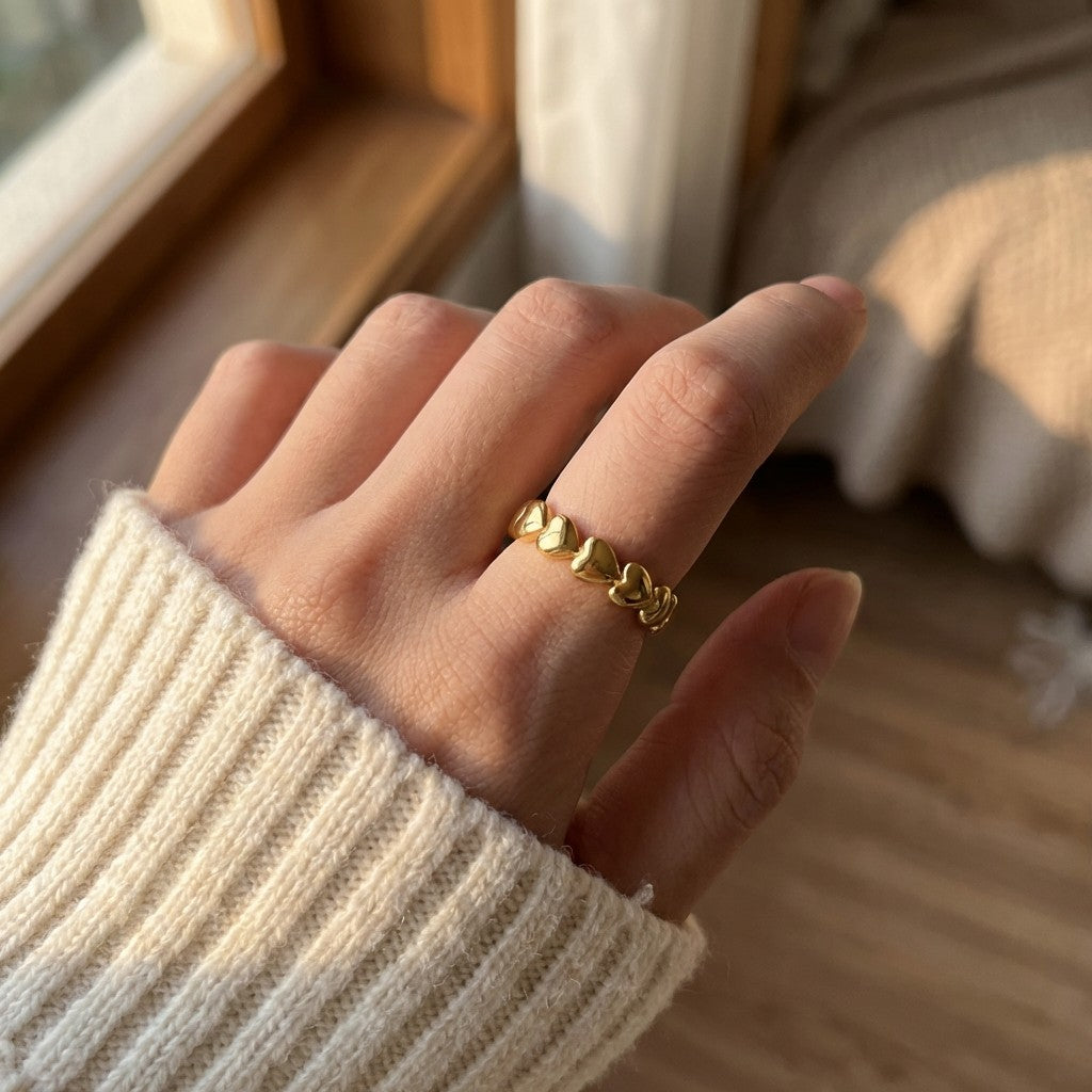 gold stainless steel heart-shaped ring on person's hand