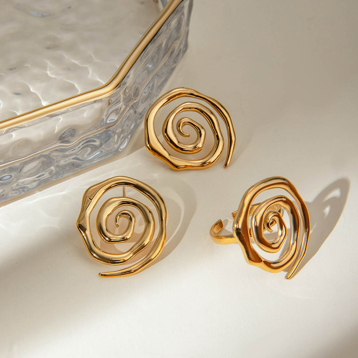 Gold spiral earrings on a light background