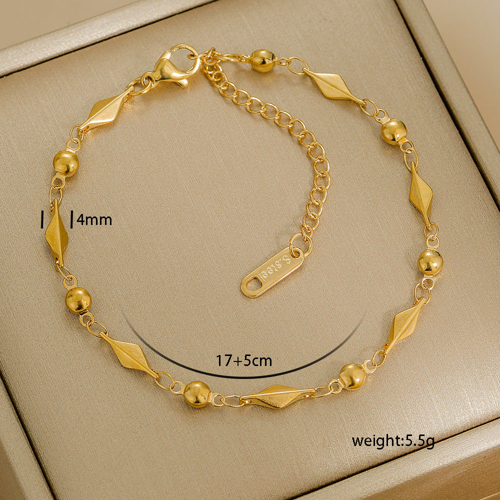 Gold bracelet with measurements on a beige background