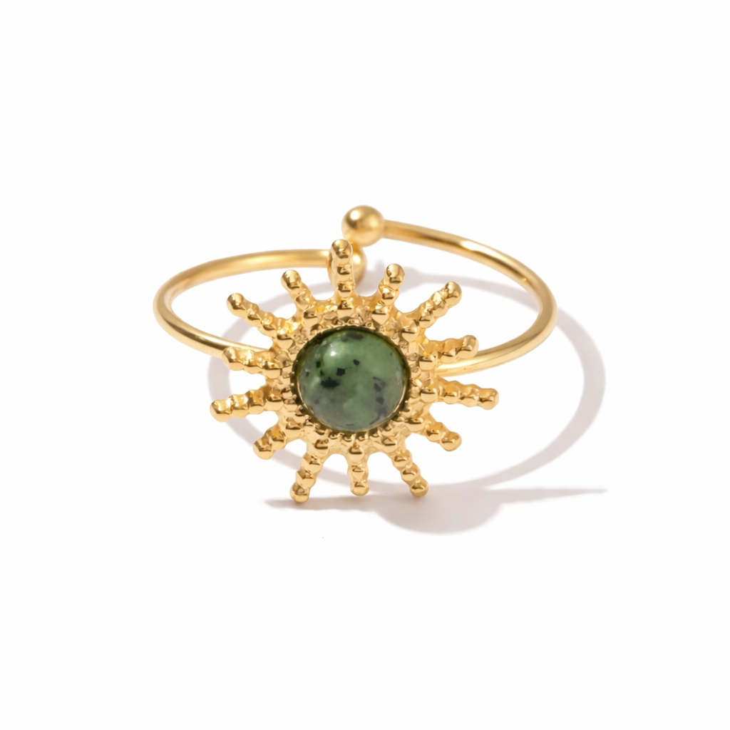 Gold ring with a green stone on a white background
