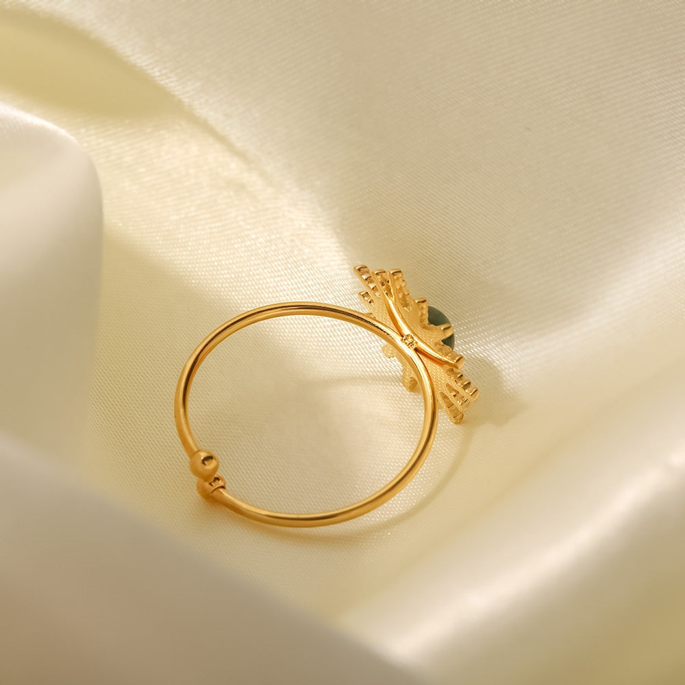 Gold open ring on a soft beige fabric background