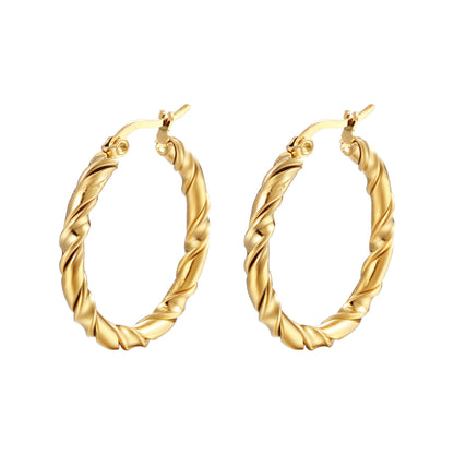 Gold hoop earrings with twisted design on a white background