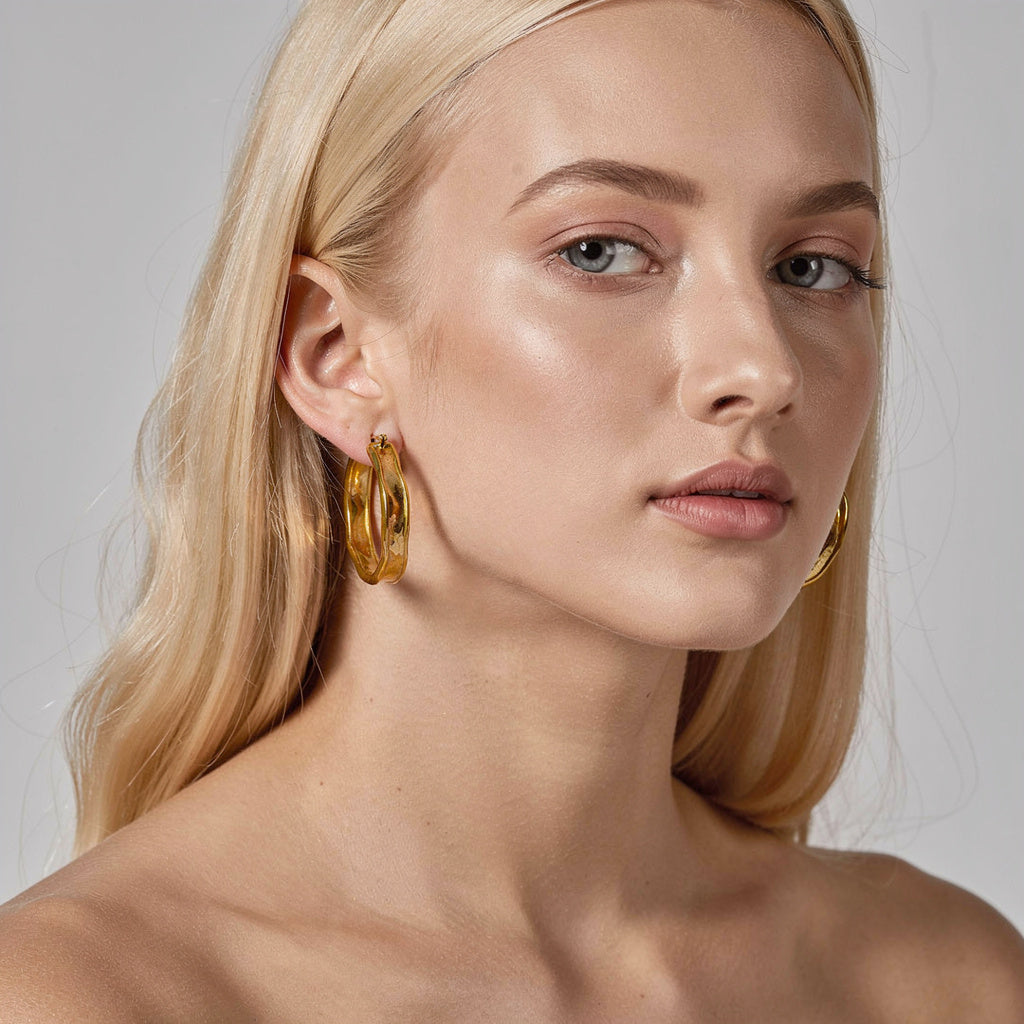 a woman wearing gold statement hoops