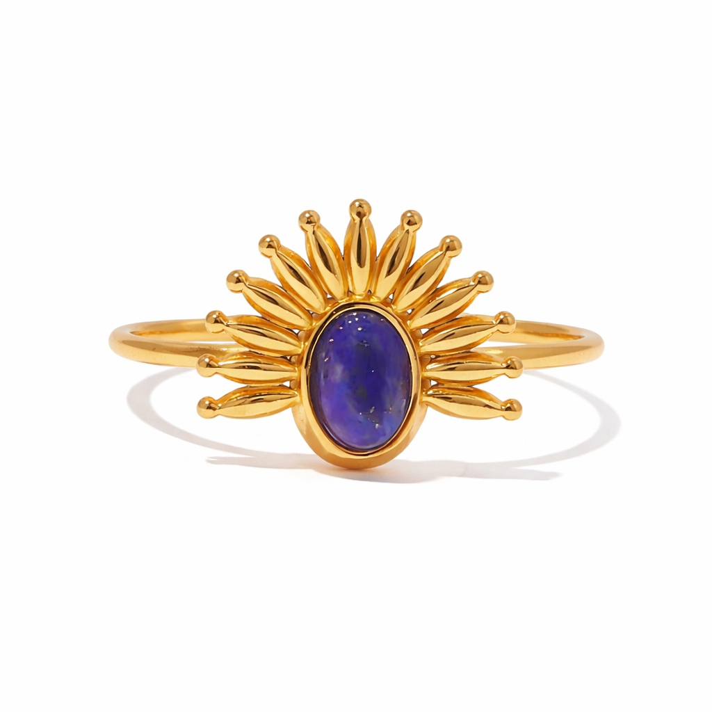 Gold ring with a navy blue gemstone on a white background