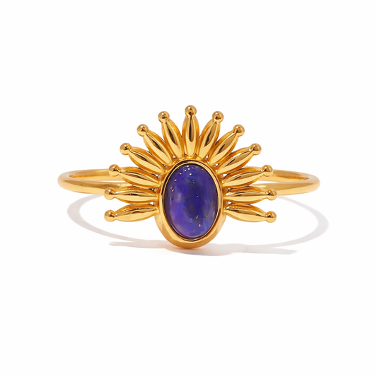 Gold ring with a navy blue gemstone on a white background