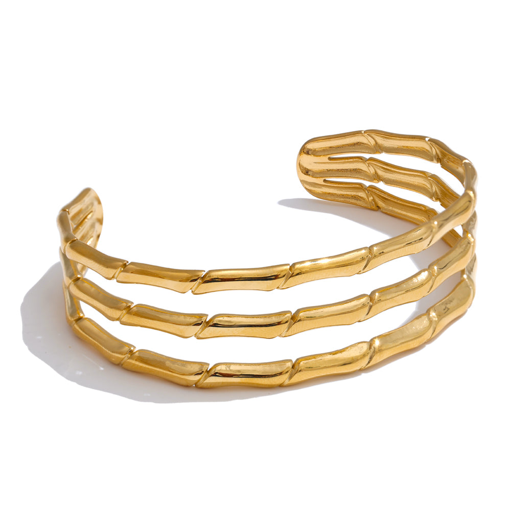 Gold stainless steel bangle on white background