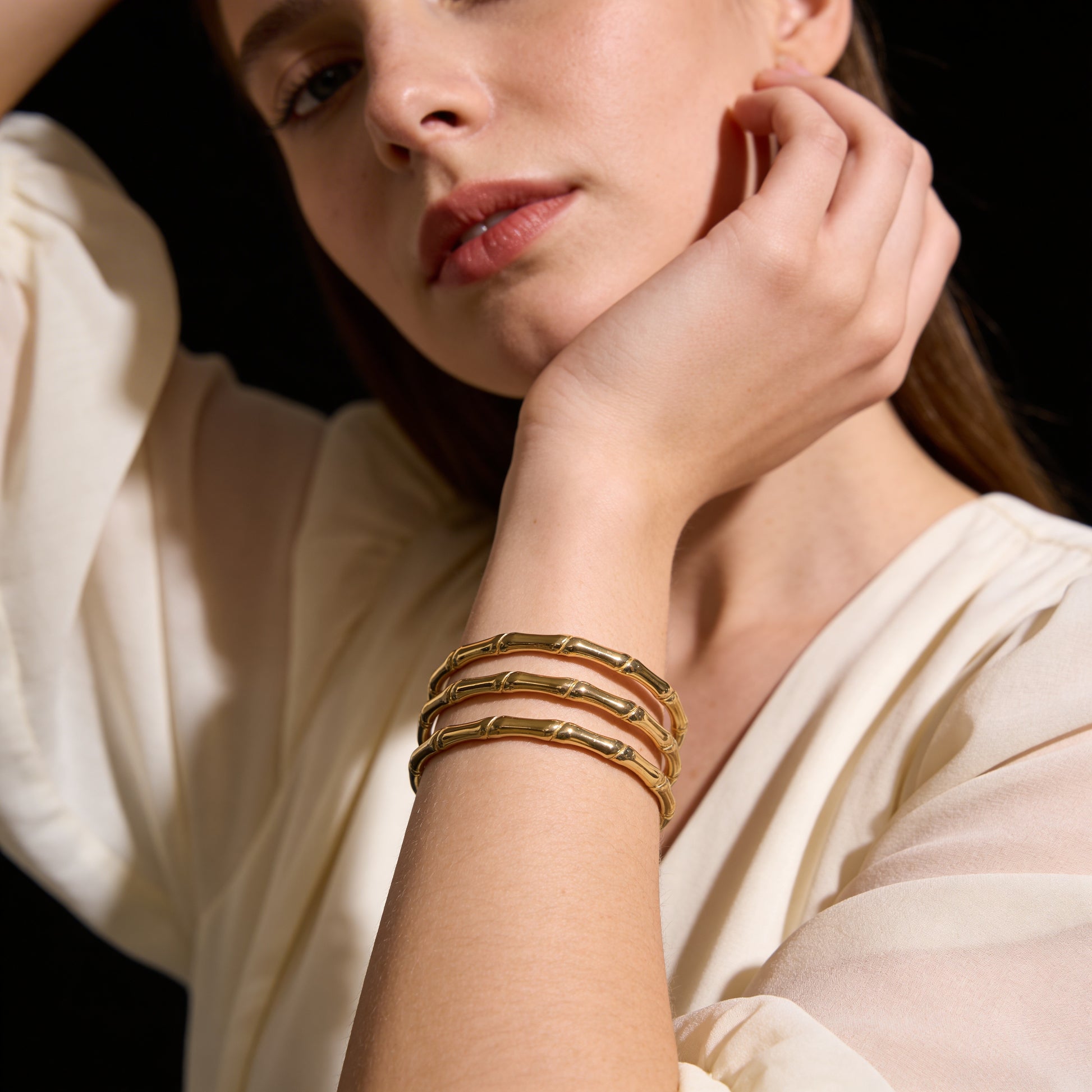a woman wearing gold statement bracelet