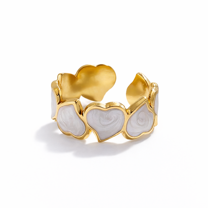 Gold ring with heart-shaped designs on a white background