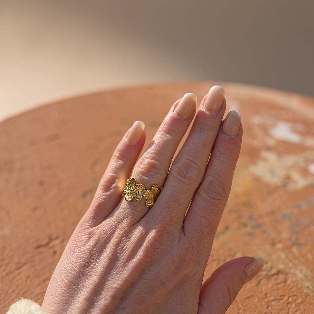 Hand wearing a gold affordable ring with a blurred background