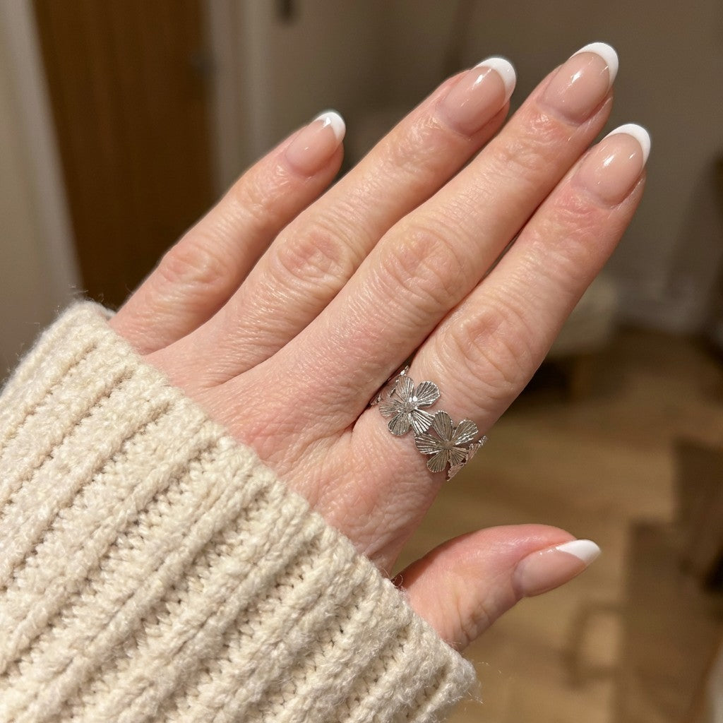 hand wearing silver floral ring
