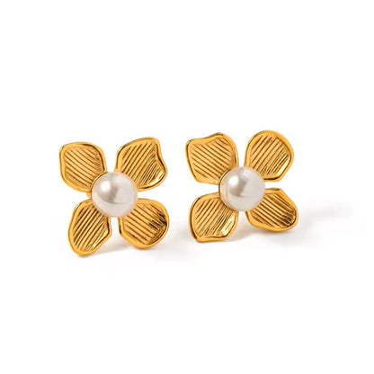 Gold flower-shaped earrings with pearl centers on a white background