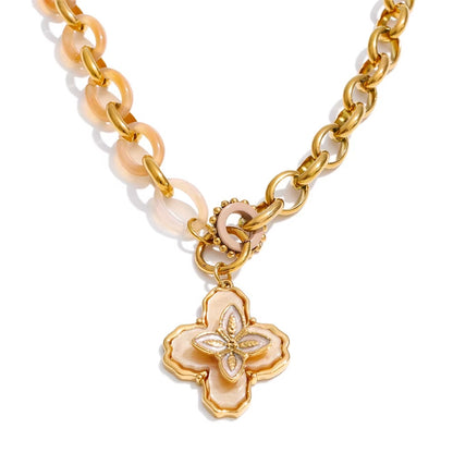 Gold chain necklace with a clover pendant on a white background
