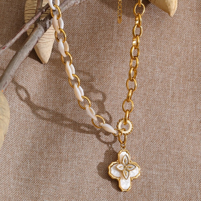 Necklace with gold chain and beige pendant on a textured beige background
