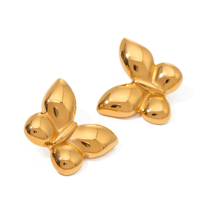 Pair of gold butterfly-shaped statement earrings on a white background