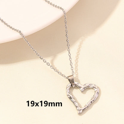 Silver heart-shaped pendant necklace on a beige background