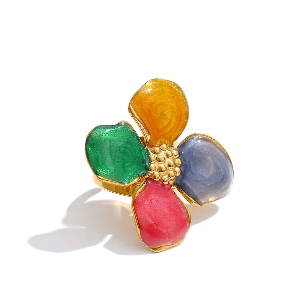 Multicolored flower-shaped ring with gold center on a white background