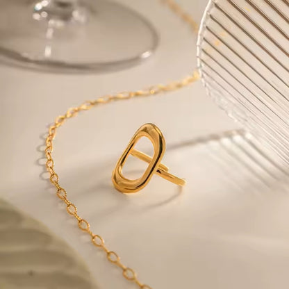 Gold ring with a chain on a light background