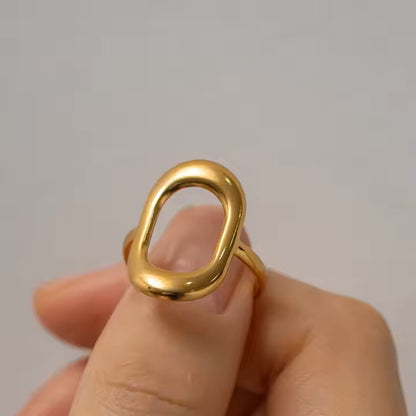 Gold ring held on a neutral background