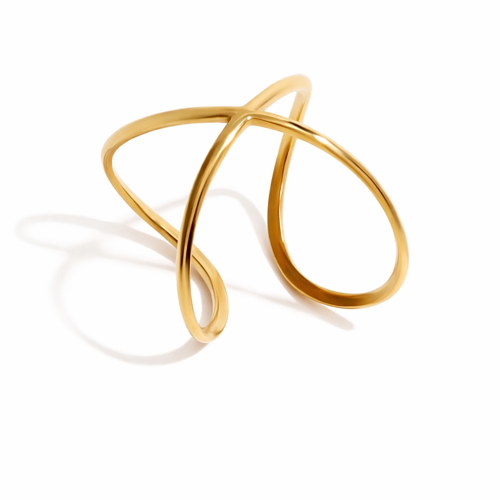 Delicate gold ring with a twisted design on a white background