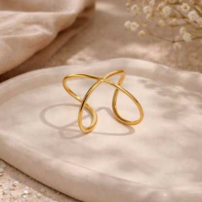 Gold ring on a beige fabric background with dried flowers