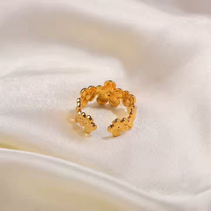 Gold ring with floral design on a white fabric background