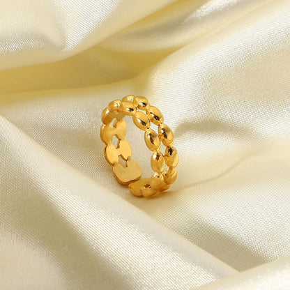Gold waterproof chain ring on a beige satin background