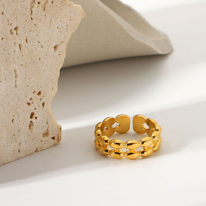 Gold ring on a light surface with a stone-like object in the background
