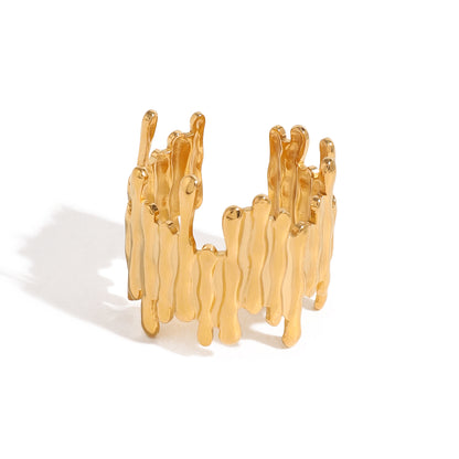 Gold ring with wavy design on a white background