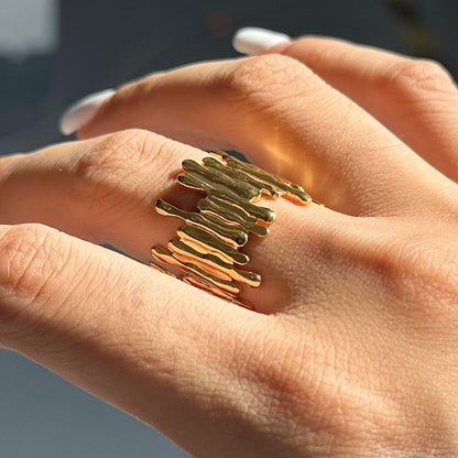 Gold ring on a person's finger with a blurred background