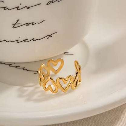 Gold heart-shaped ring on a white saucer with cursive text