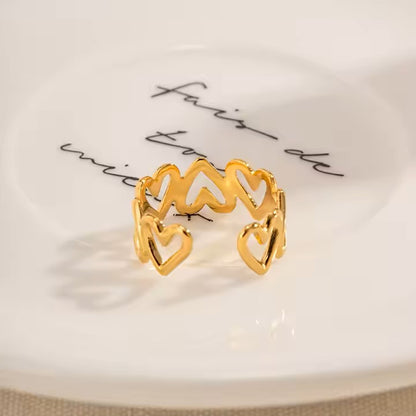 Gold ring with heart designs on a white surface