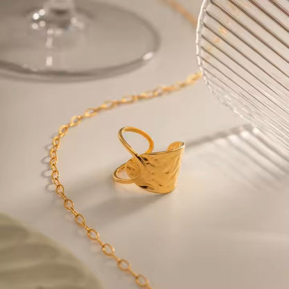 Gold ring with chain on a light surface