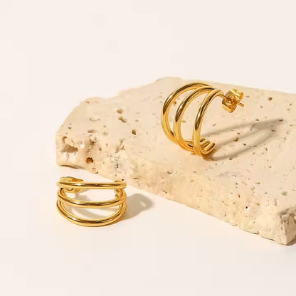 Two gold rings on a textured beige surface