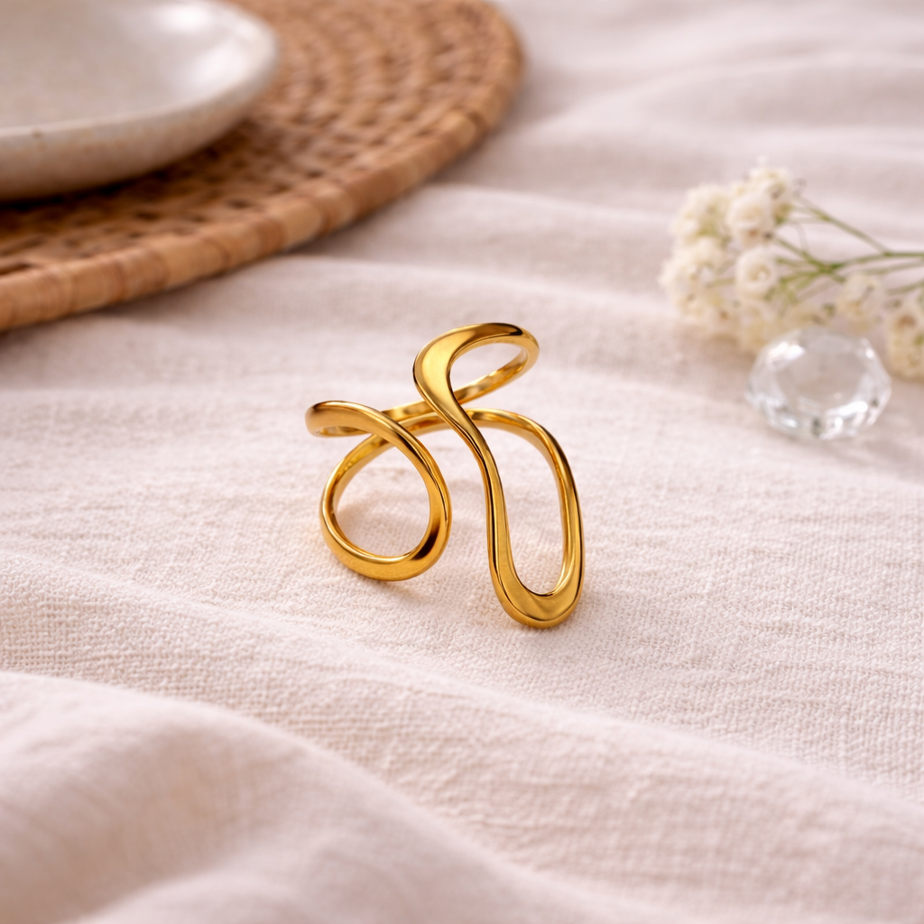 Elegant gold ring with a decorative design on a light fabric background