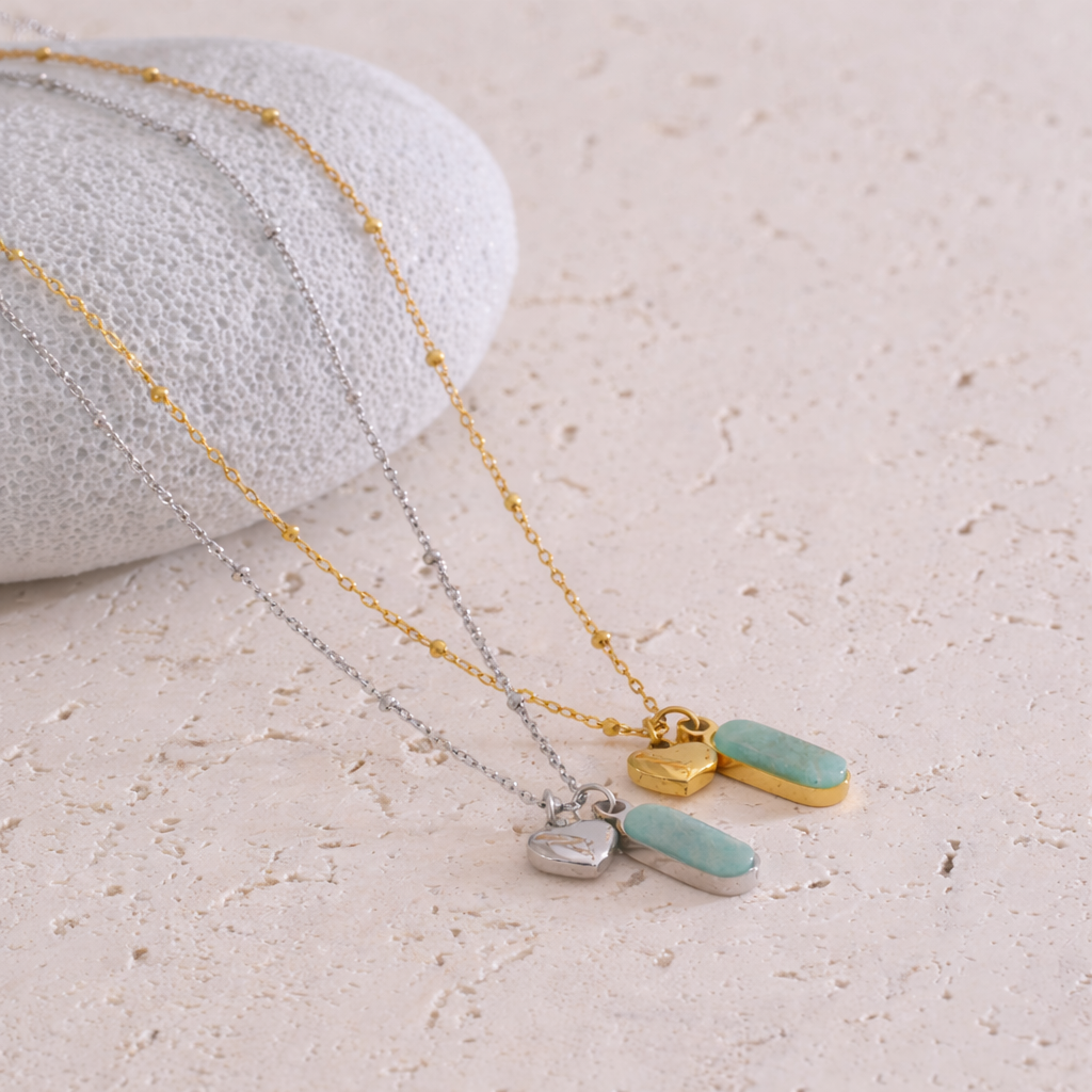 Two necklaces with pendant charms on a textured surface