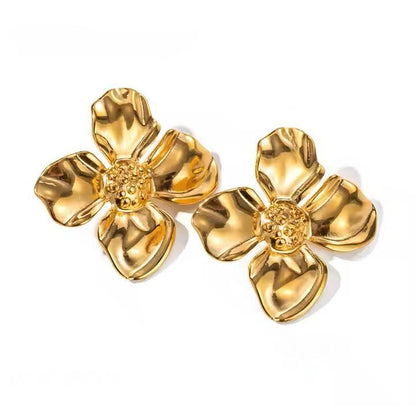 Pair of gold flower-shaped earrings on a white background