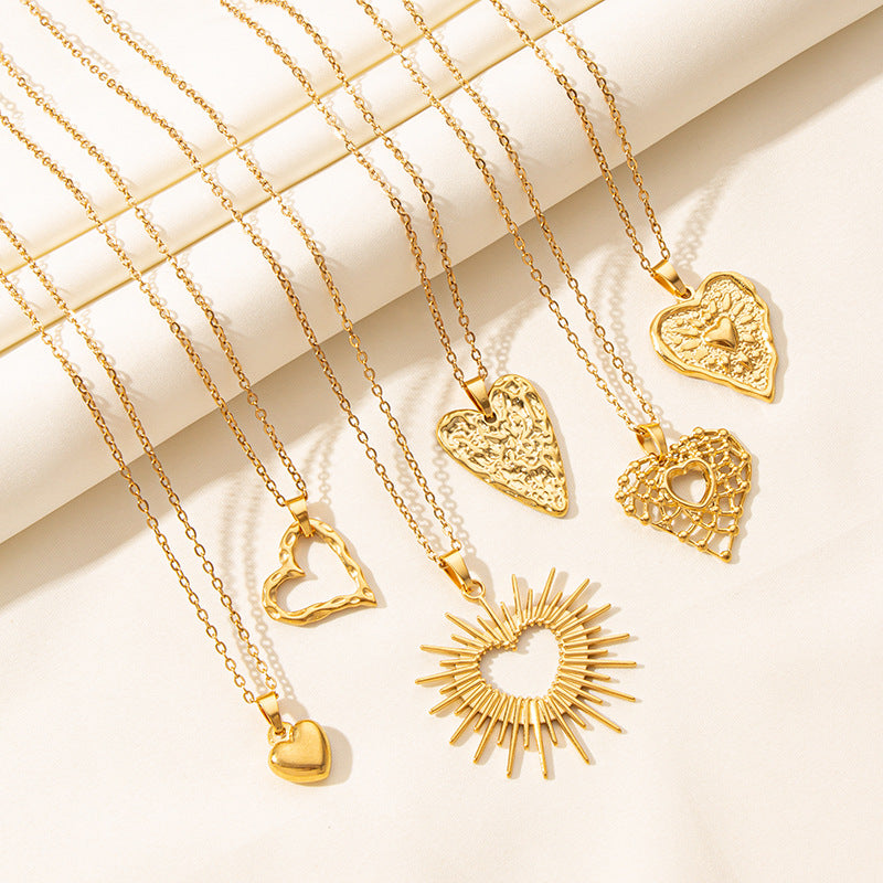 Gold waterproof necklaces with heart-shaped pendants on a light background
