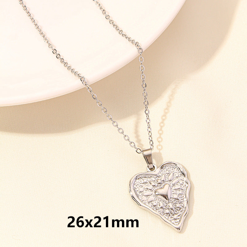 Heart-shaped silver pendant necklace on a beige background